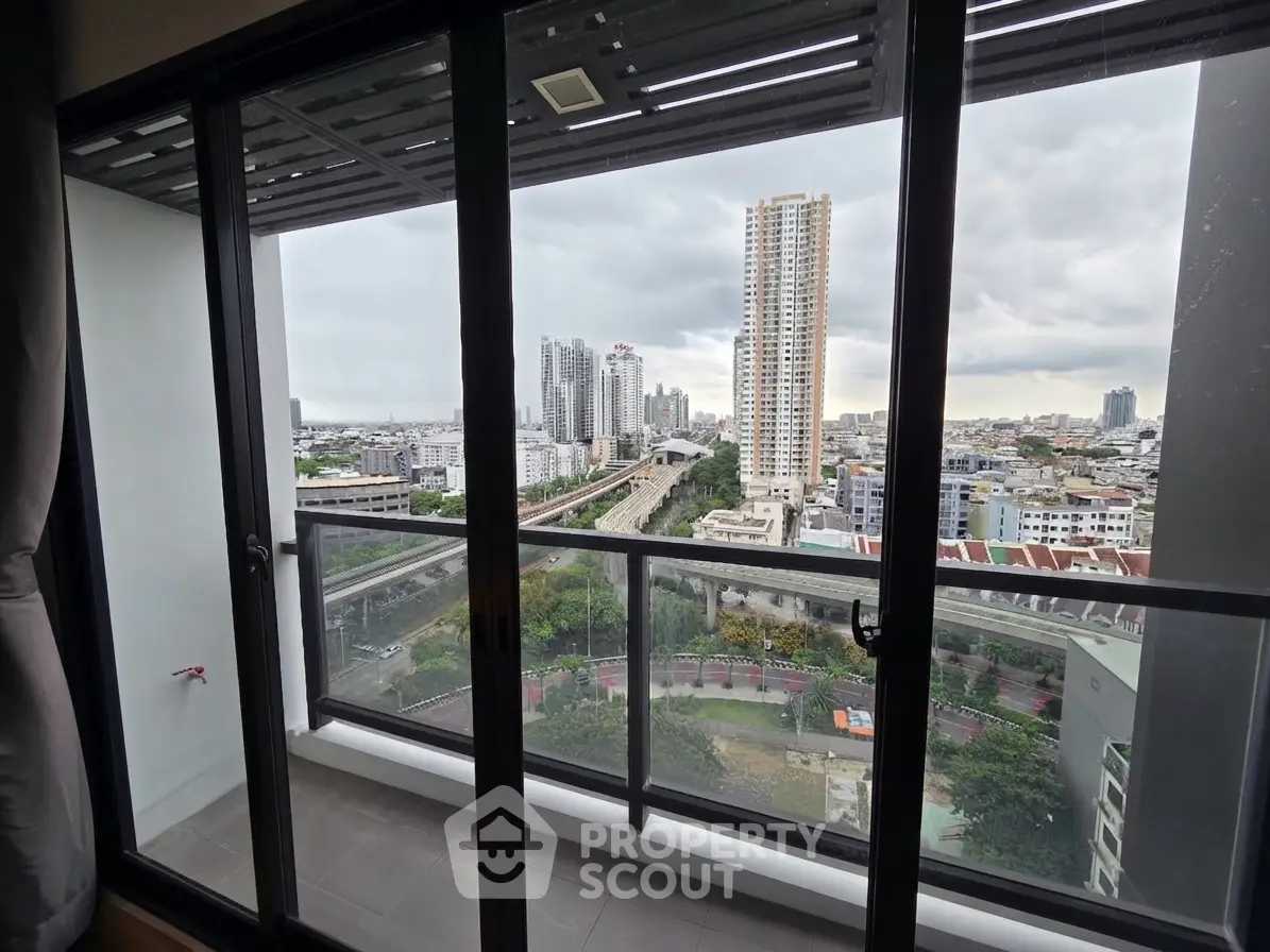 Stunning cityscape view from a modern apartment balcony with glass railing.