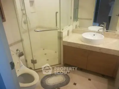Modern bathroom with glass shower and elegant vanity in a stylish home.
