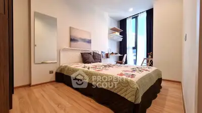 Spacious bedroom with modern decor and large window for natural light.