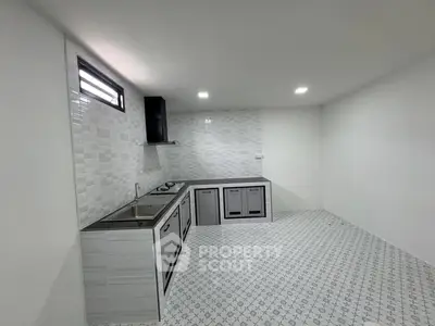 Modern minimalist kitchen with sleek cabinetry and tiled flooring