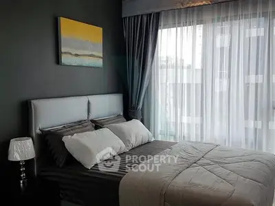 Modern bedroom with stylish decor and large window in a contemporary apartment.