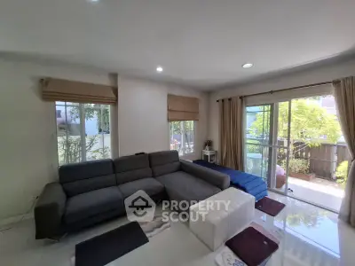 Spacious living room with modern sofa and large windows overlooking garden