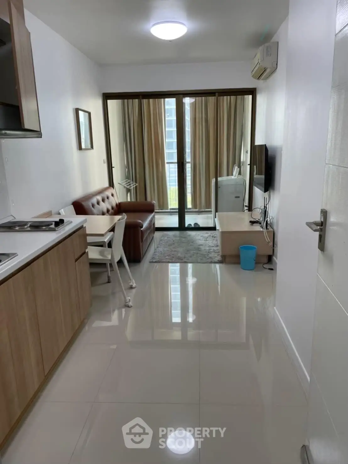 Modern open-plan living room with sleek kitchen and balcony view