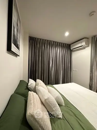 Cozy bedroom with modern decor and air conditioning, featuring elegant curtains and stylish bedding.