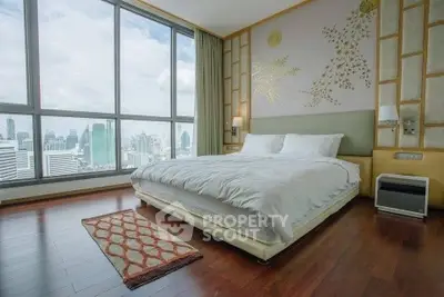 Luxurious bedroom with stunning city view and elegant decor in high-rise apartment.