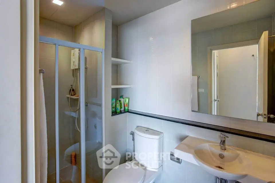 Modern bathroom with glass shower and sleek fixtures in a contemporary home.