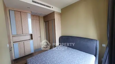 Modern bedroom with stylish wooden wardrobe and cozy bed in a contemporary apartment.