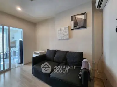 Cozy living room with modern decor and adjacent kitchen area in a stylish apartment.