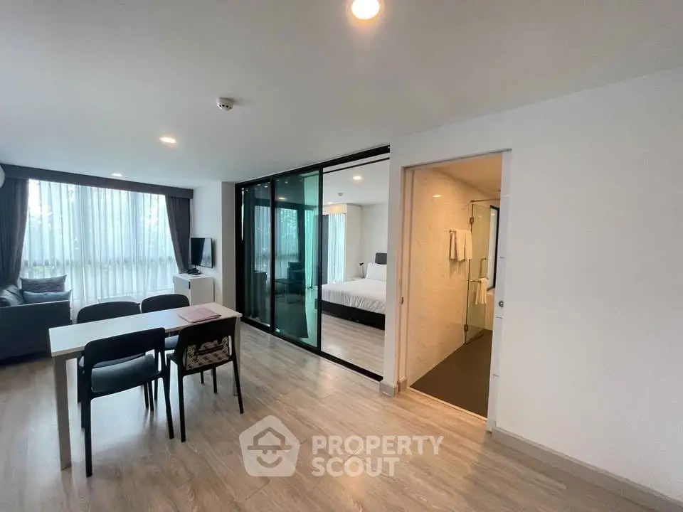 Modern open-plan living room with dining area and bedroom view