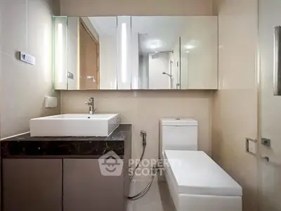 Modern bathroom with sleek fixtures and large mirror in a contemporary apartment.