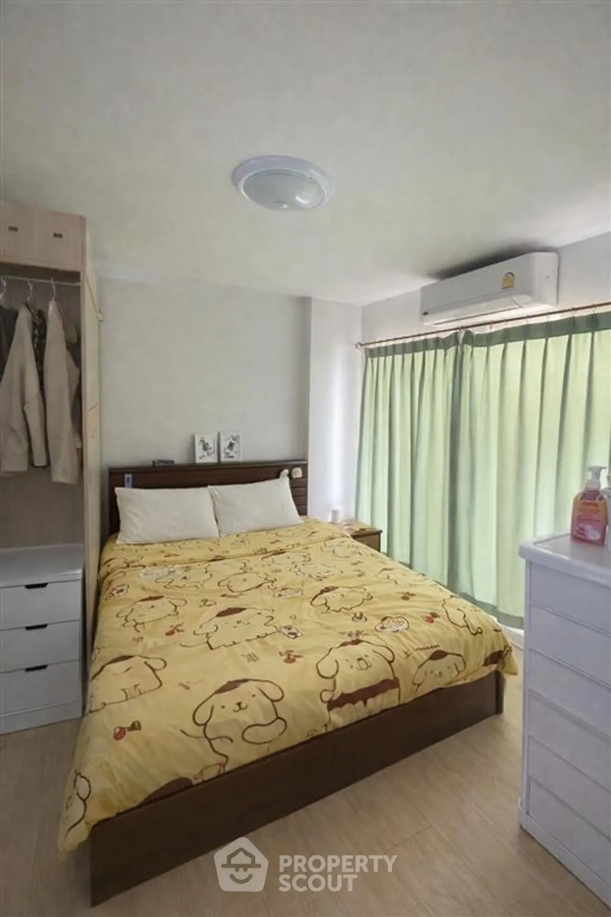 Cozy bedroom with natural light, featuring a comfortable bed and ample storage space.