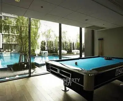 Luxurious indoor pool view with billiards table in modern apartment complex.