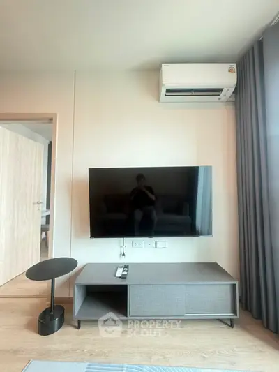 Modern living room with sleek TV setup and air conditioning, perfect for comfortable living.