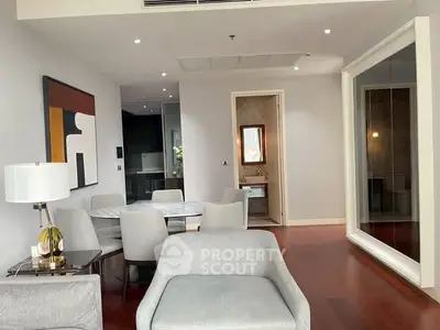 Modern living room with elegant decor and dining area, featuring stylish furniture and contemporary artwork.