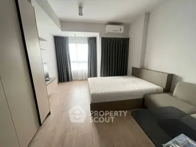 Modern bedroom with minimalist design, featuring a large window and sleek furnishings.