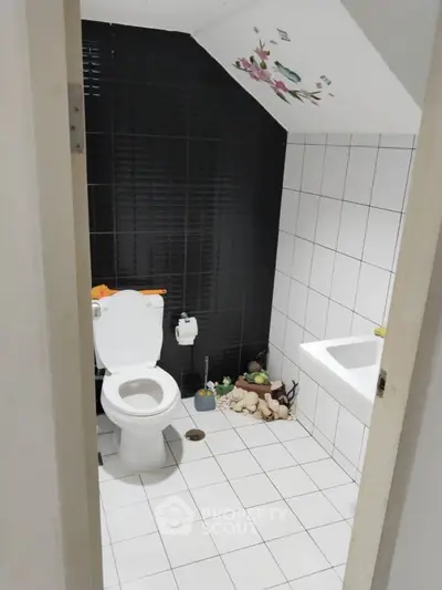 Charming bathroom with modern black and white tiles and decorative accents.