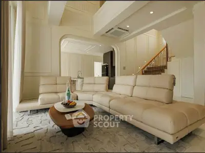Luxurious living room with elegant beige sofas and modern decor in a spacious open layout.