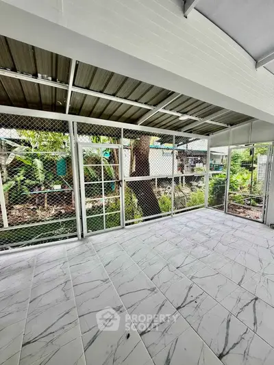 Spacious tiled patio with garden view, perfect for relaxation and outdoor activities.