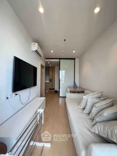 Modern living room with sleek design and large TV, perfect for relaxation.