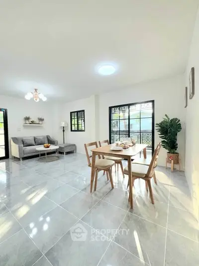 Spacious modern living and dining area with natural light and elegant decor.