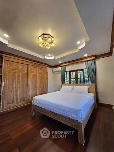 Spacious bedroom with elegant wooden furniture and ambient lighting