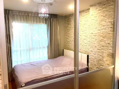 Cozy bedroom with stone accent wall and elegant chandelier lighting