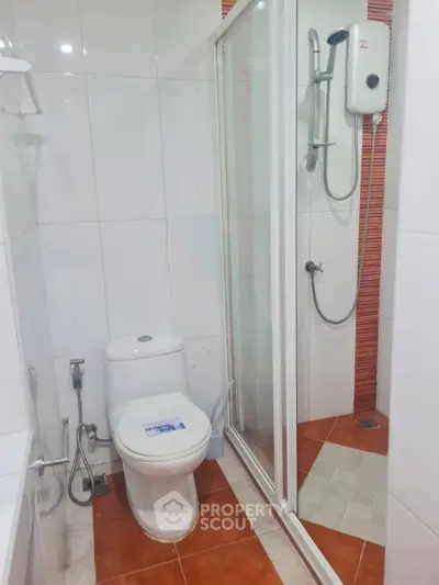 Modern bathroom with shower enclosure and white fixtures in a real estate property.