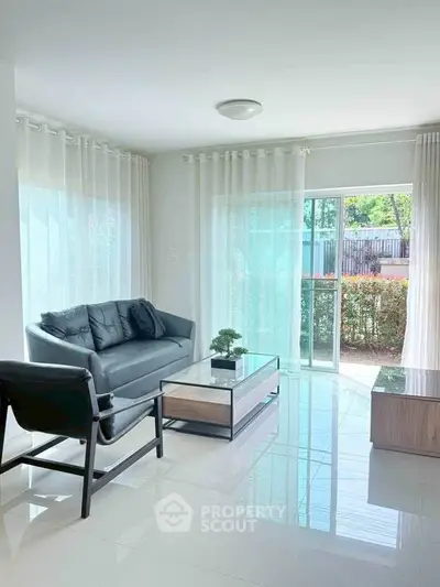Bright modern living room with sleek furniture and large windows overlooking garden.