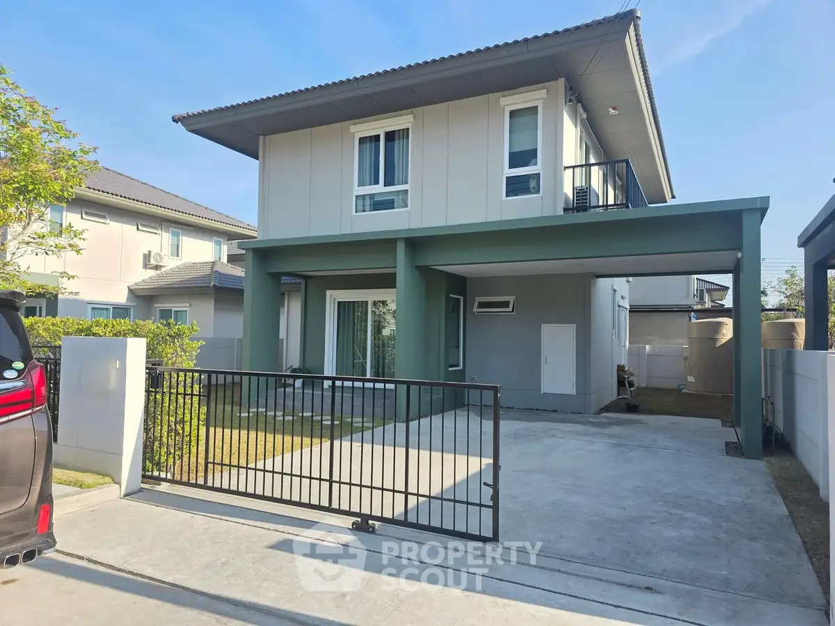 Modern two-story house with driveway and small balcony in a suburban neighborhood.