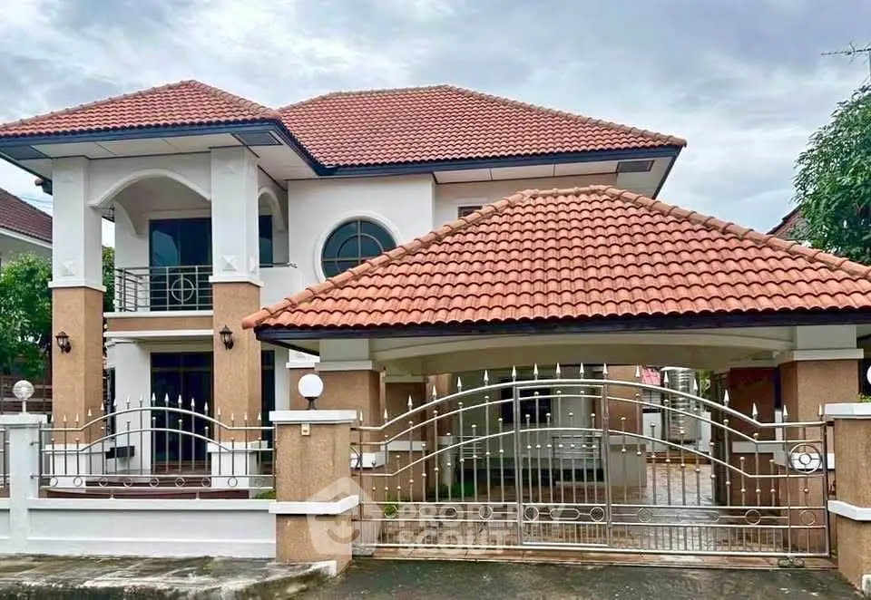 Charming two-story house with red tile roof and elegant gated entrance