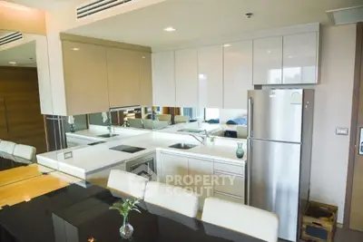 Modern kitchen with sleek cabinetry and stainless steel appliances in a stylish apartment.