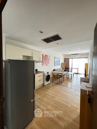 Spacious open-plan living area with modern kitchen and natural light