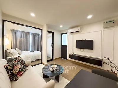 Modern living room with adjacent bedroom, featuring sleek design and cozy ambiance.