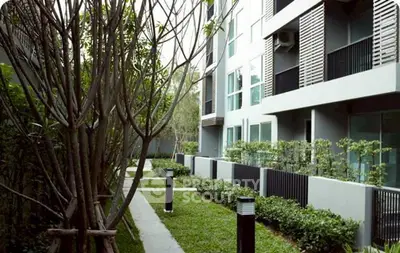 Modern apartment building with lush garden and sleek exterior design
