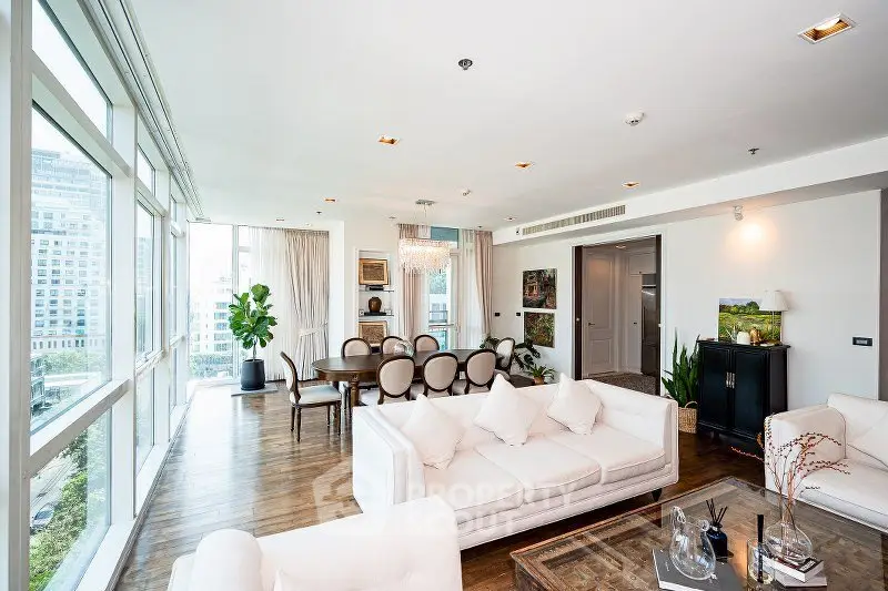 Luxurious open-plan living room with elegant dining area and panoramic city views.