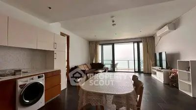 Spacious living room with sea view, modern kitchen, and elegant dining area.