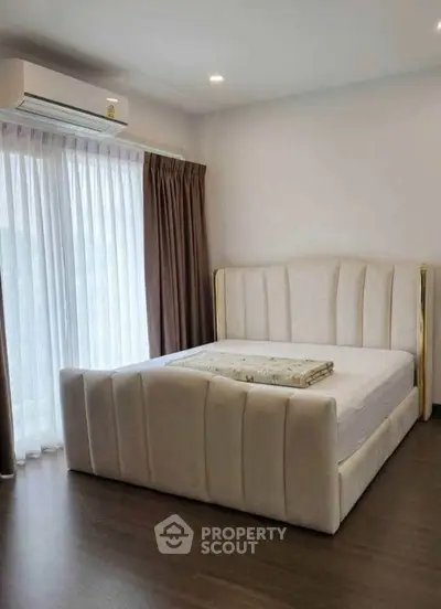 Luxurious bedroom with elegant bed and large window for natural light.