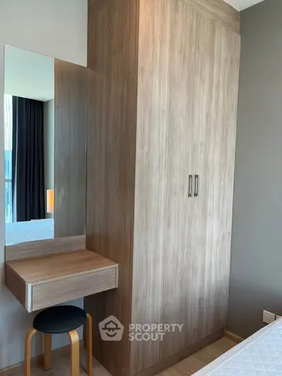 Modern bedroom with wooden wardrobe and vanity mirror