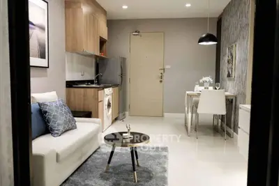 Modern living room with compact kitchen and dining area, featuring stylish decor and cozy ambiance.