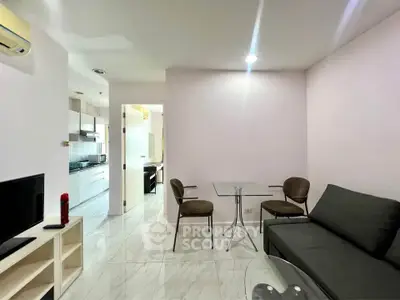 Modern living room with sleek furniture and open kitchen layout in a stylish apartment.