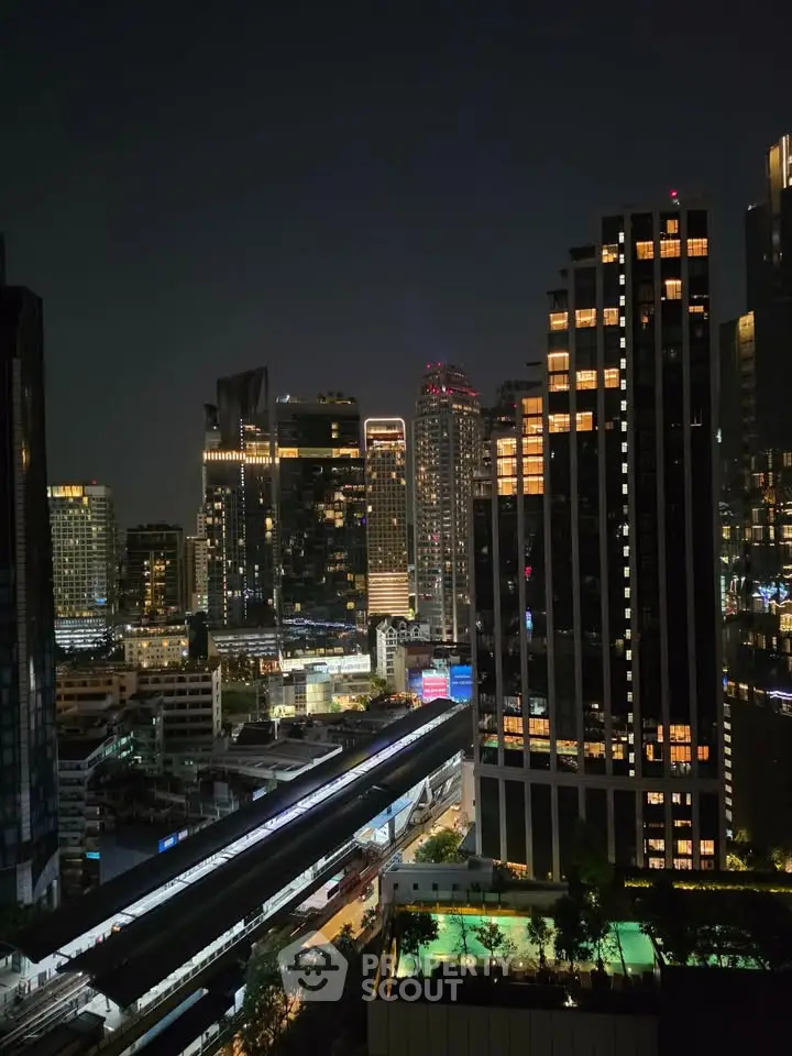 Stunning night view of a vibrant city skyline with illuminated skyscrapers and bustling streets.