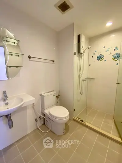 Modern bathroom with glass shower and sleek fixtures in a contemporary apartment.
