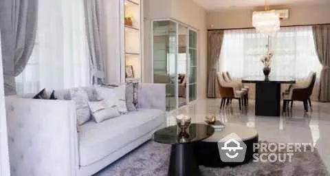 Elegant living room with modern decor and dining area, featuring a chic chandelier and large windows.