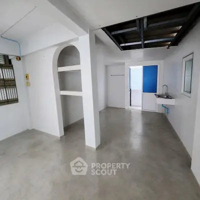 Spacious open-plan interior with modern minimalist design and built-in shelving, perfect for customization.
