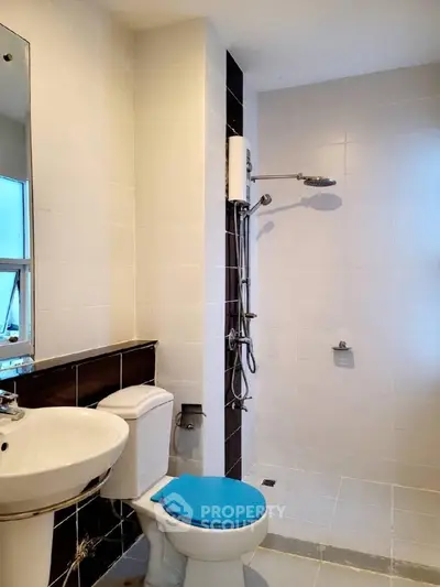 Modern bathroom with shower and sleek fixtures in a bright, tiled space.