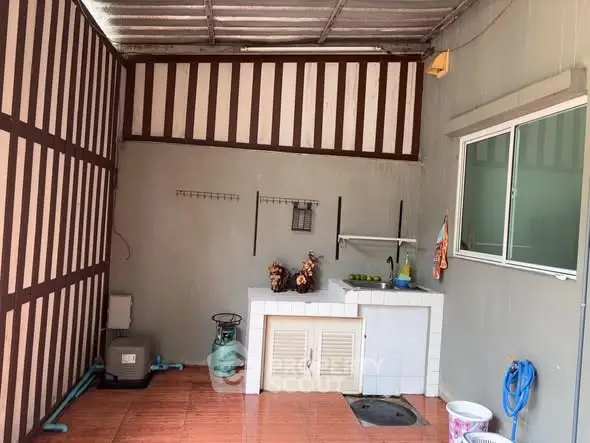 Charming outdoor kitchen with tiled flooring and rustic wooden accents.