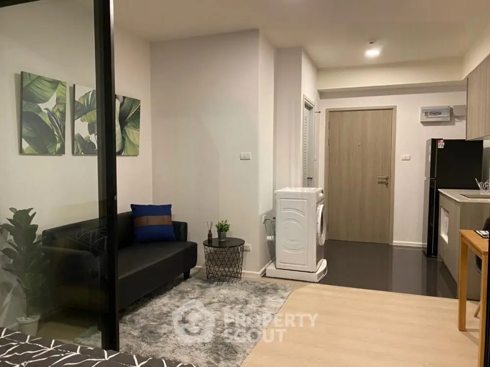 Modern studio apartment with stylish decor, featuring a cozy living area and compact kitchen.