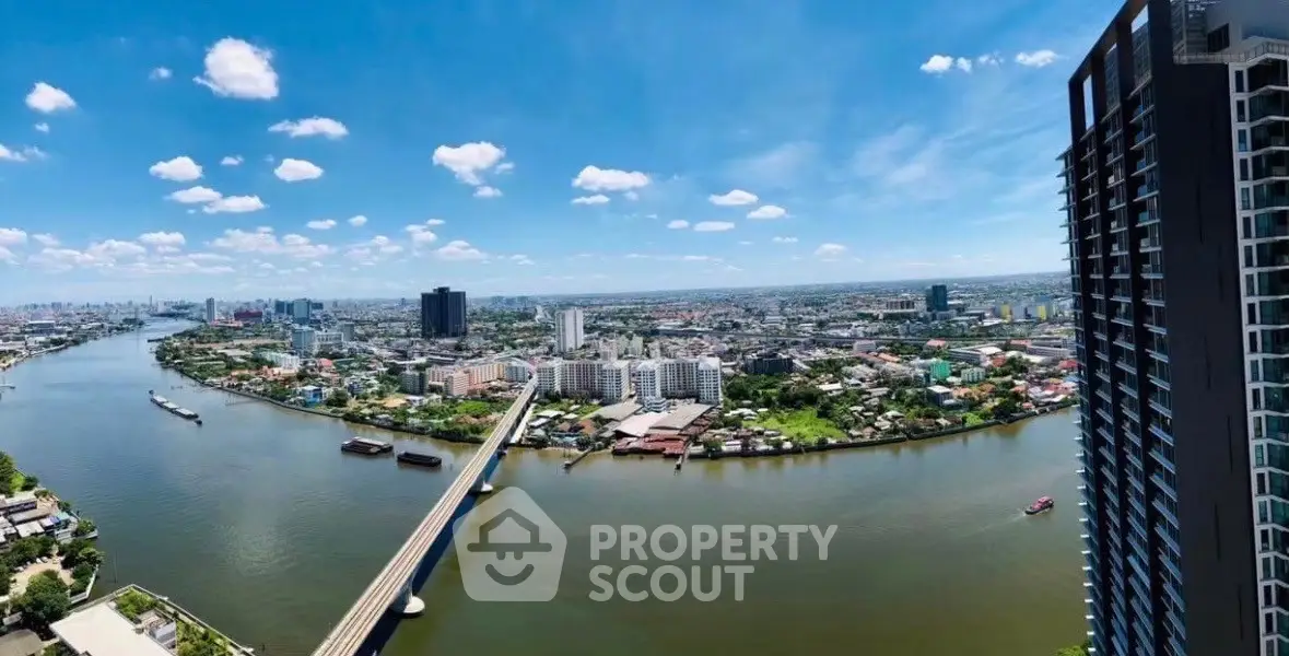 Stunning panoramic cityscape view from high-rise building overlooking river and skyline.