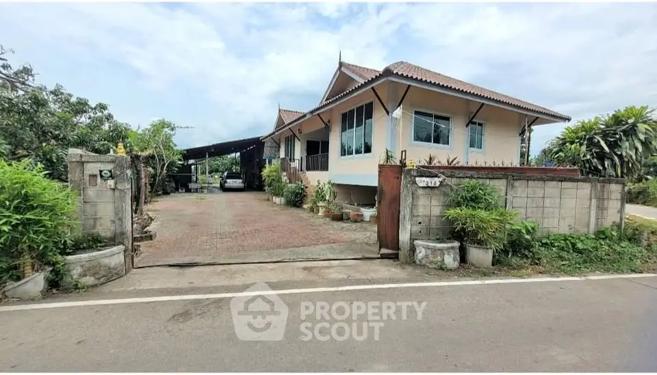 Charming single-story house with spacious driveway and lush greenery, perfect for serene living.