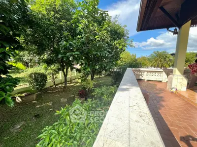 Charming garden view from a spacious balcony in a serene residential area.